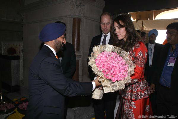 William and Kate are prestented with flowers at the Taj Palace