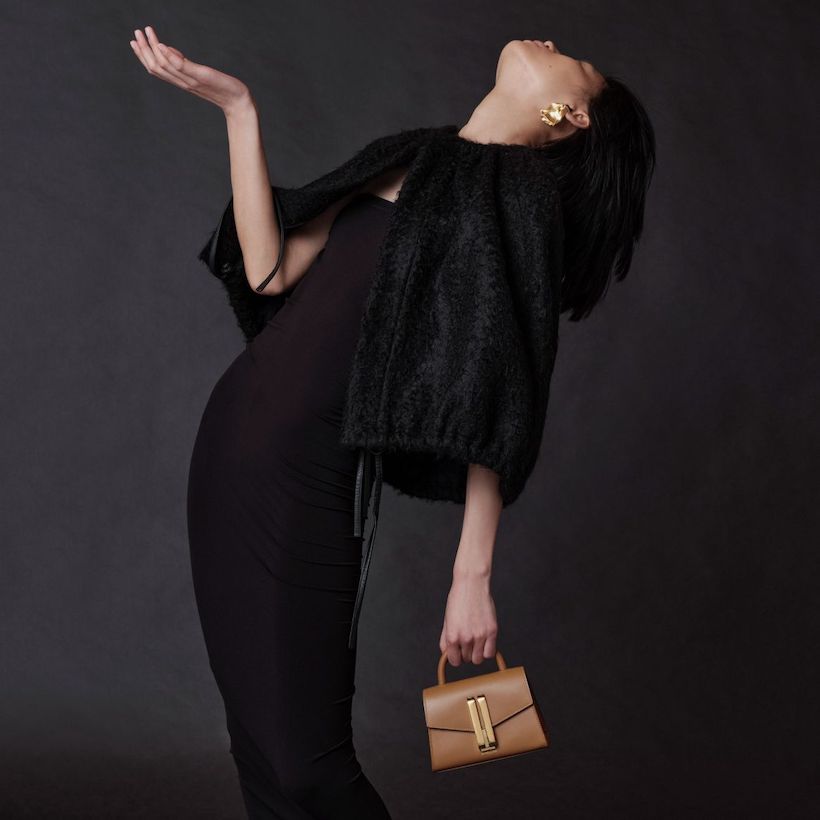 Model carrying the Nano Montreal bag in toffee. Model is dressed in black eveningwear.