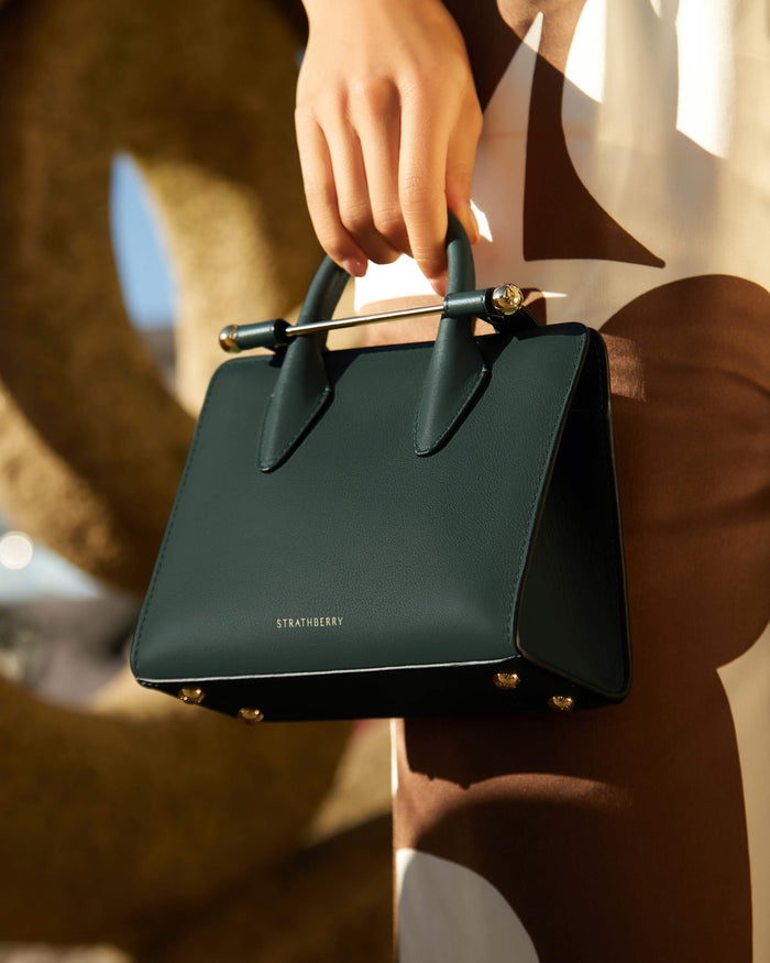 Model holding a Strathberry bag
