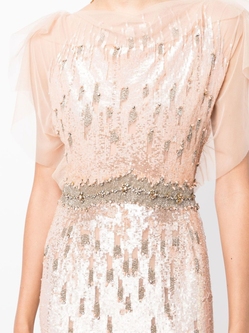 A close up look at the gown's elegant silver waist beading, which forms a band across the middle of the dress. The fabric is sequinned and adorned with crystals across the bust.. You can also see the delicate tulle shoulder detailing.