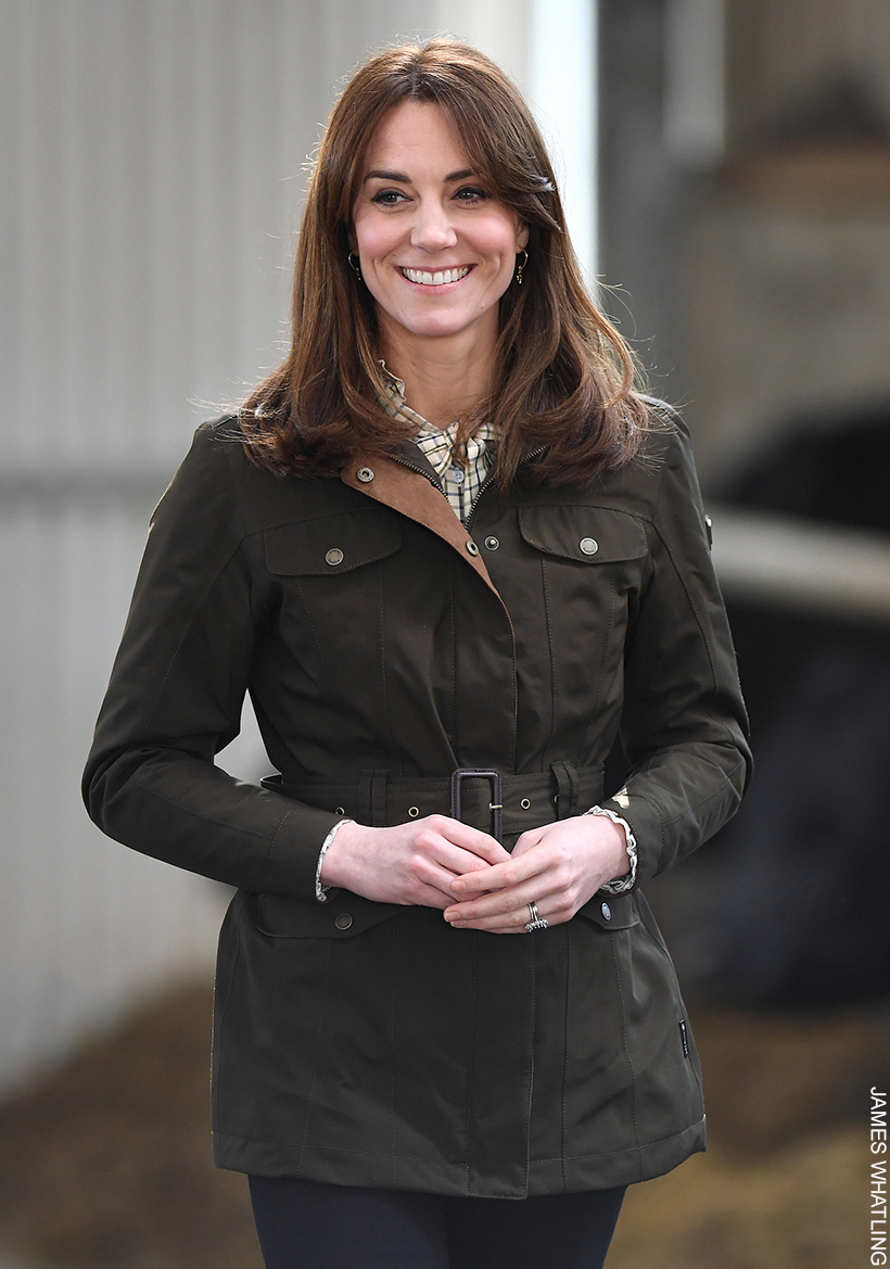 Kate Middleton, grinning, wearing her dark green Dubarry utility jacket.