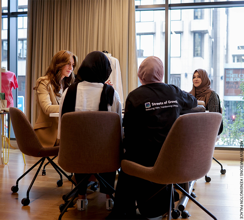 The Princess sits with women from Streets of Growth. They are sat in conversation.