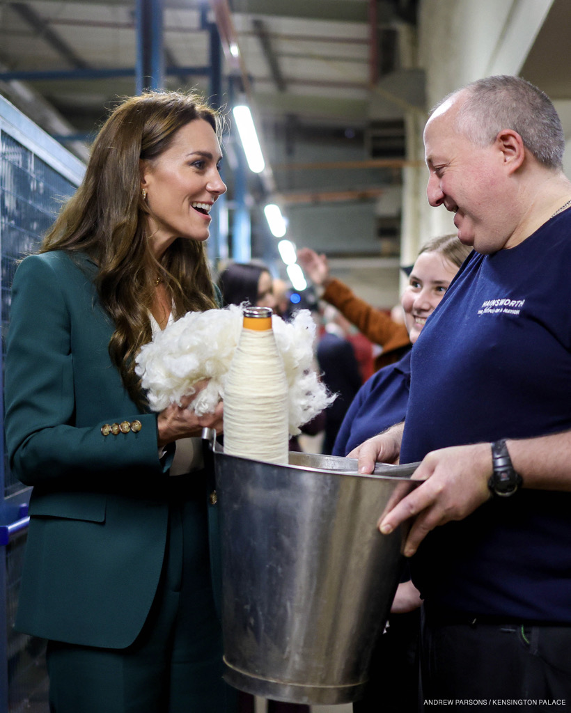 The Princess looking animated, chatting to workers, while holding a handful of wool.