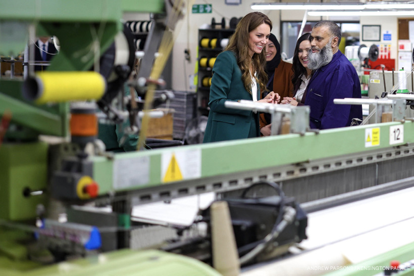 The Princess chatting with a member of the mill’s staff, looking at a machine.
