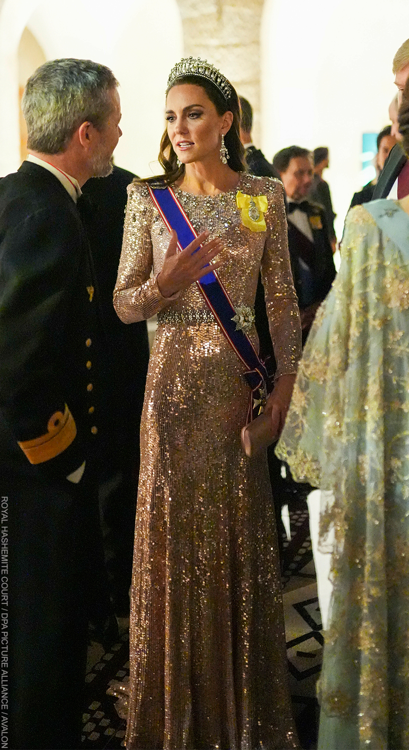 Kate Middleton chatting with guests at the Jordan Royal Wedding in 2023. She wears the Queen Mary Lover's Knot Tiara with a shimmering pink gown.