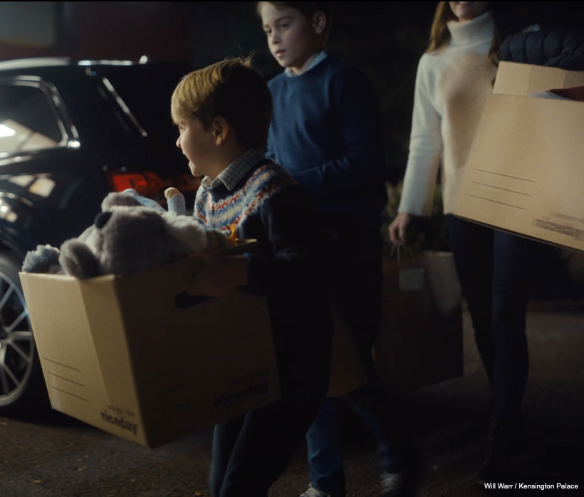 Kate, Louis and George carry boxes full of donations into the centre