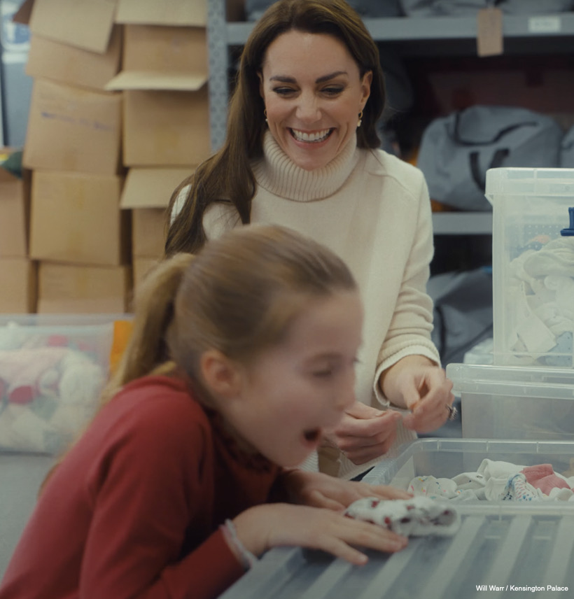 Charlotte laughs when she sees the cute babygro is covered in Welsh dragons