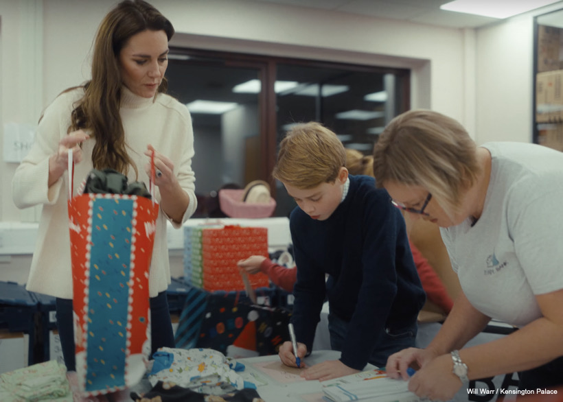 George writes a label for his bag while Kate looks on