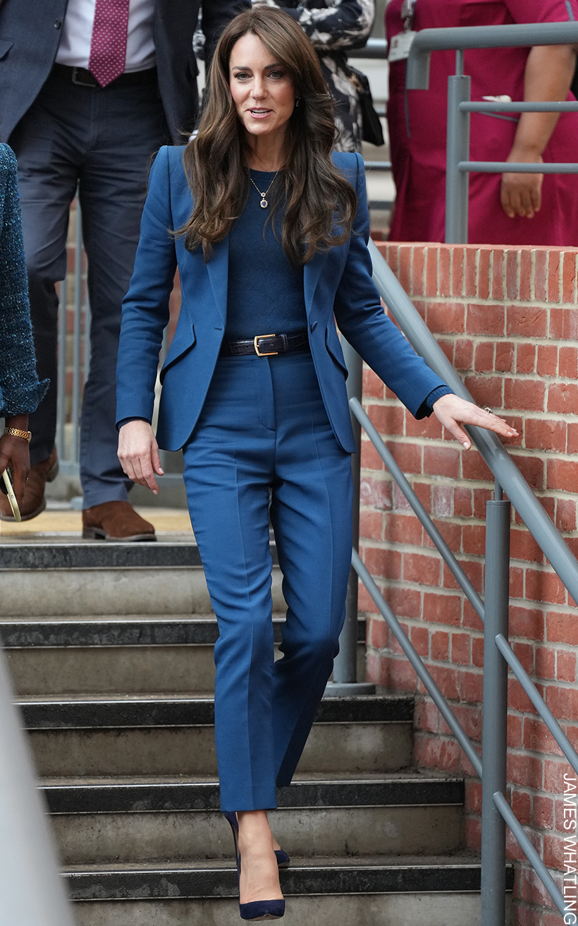 The Princess of Wales embraces one-colour dressing as she walks down a set of stairs wearing a blue suit, blue accessories, blue shoes, and a matching blue knit.