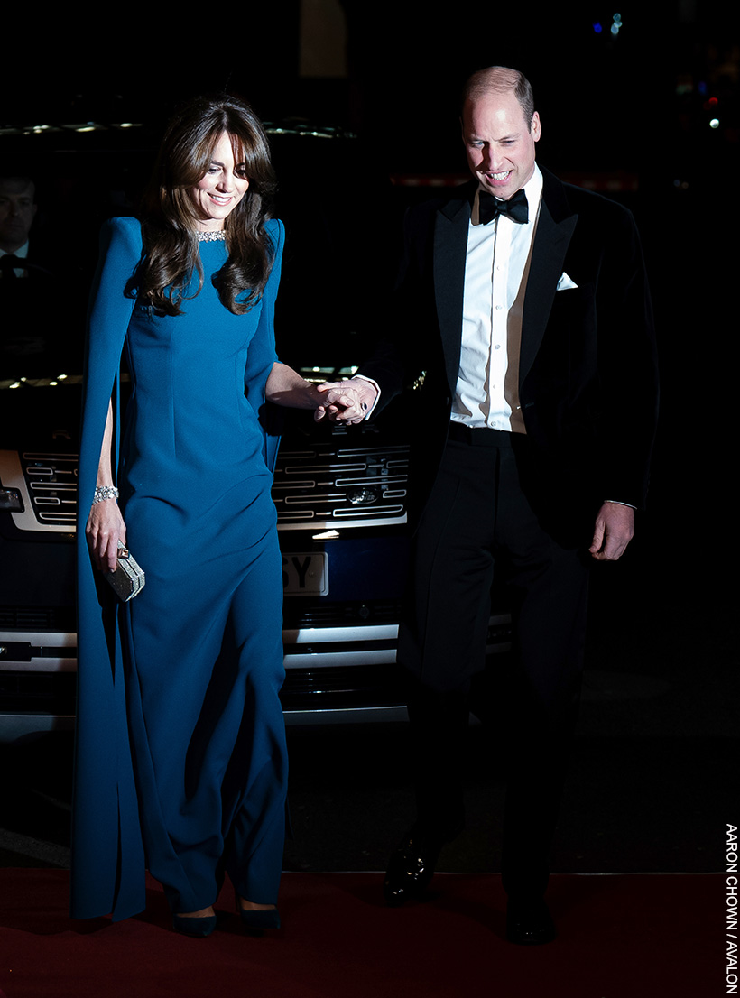 William and Kate hold hands as the prince helps his wife up the stairs of the Royal Albert Hall. Both are dressed in formalwear.