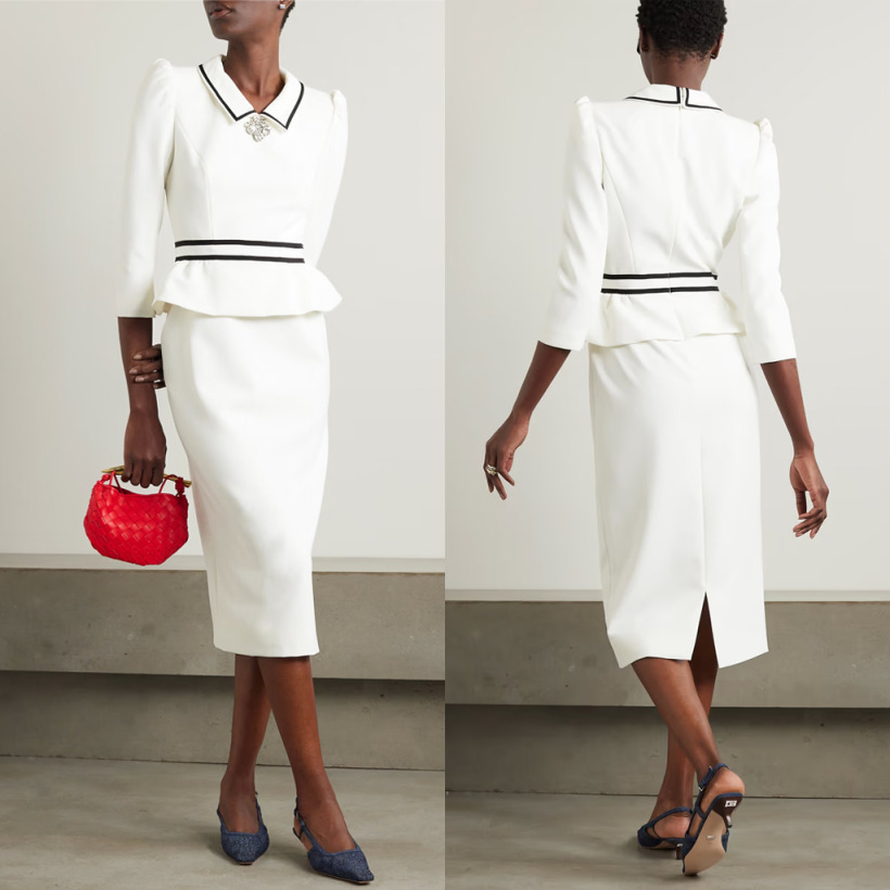 model wearing a sophisticated white cocktail dress with black trim by Jenny Packham, featuring a peplum waist, a brooch detail, and three-quarter length sleeves