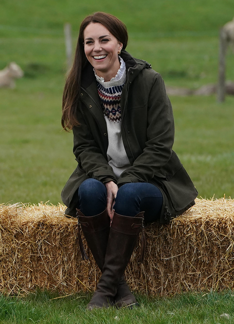 Kate Middleton in 2021 wearing the same Penelope Chilvers boots, while sat on a hay bale