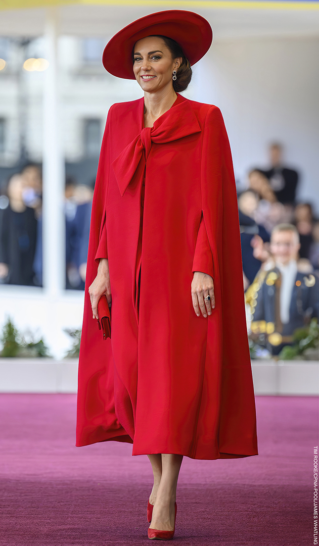 Kate Middleton wearing a dramatic red Catherine Walker cape and coat with a large bow at the South Korean State Visit welcome ceremony.