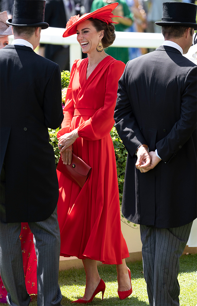 Kate Middleton dressed all in red, laughing, as she carries her red Hermes clutch.