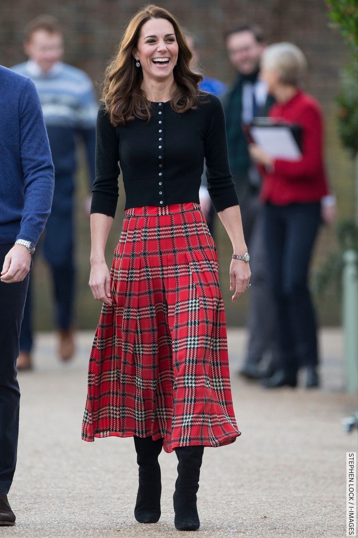 The Princess of Wales wearing a tartan maxi skirt with black boots and black cardigan 