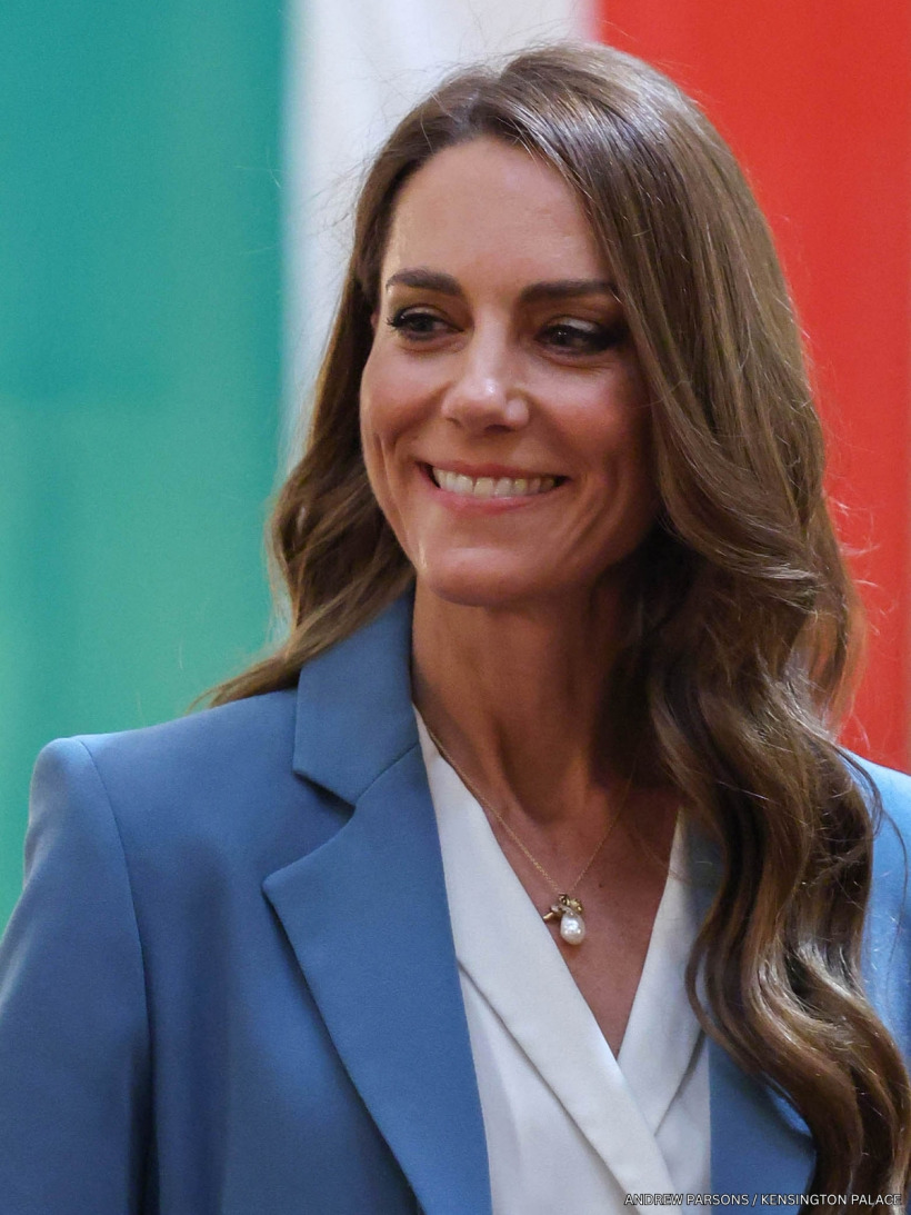 Kate Middleton in a cornflower blue Edeline Lee suit on her first solo overseas trip in nearly three years. She's stood in front of Italy's flag.