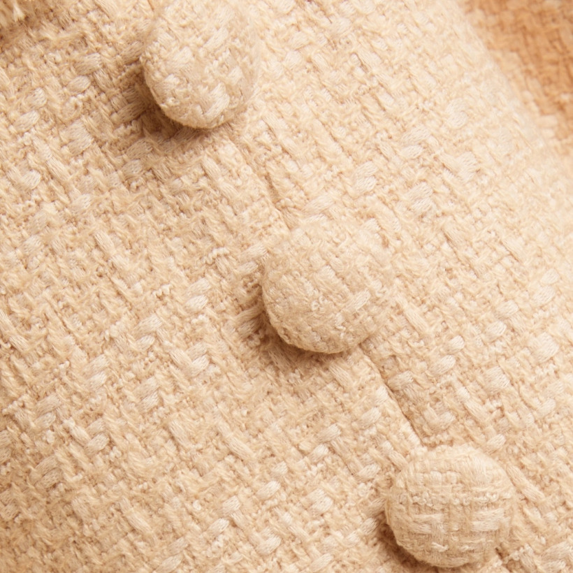 Close-up of the Roland Mouret dress showing bouclé fabric and covered buttons