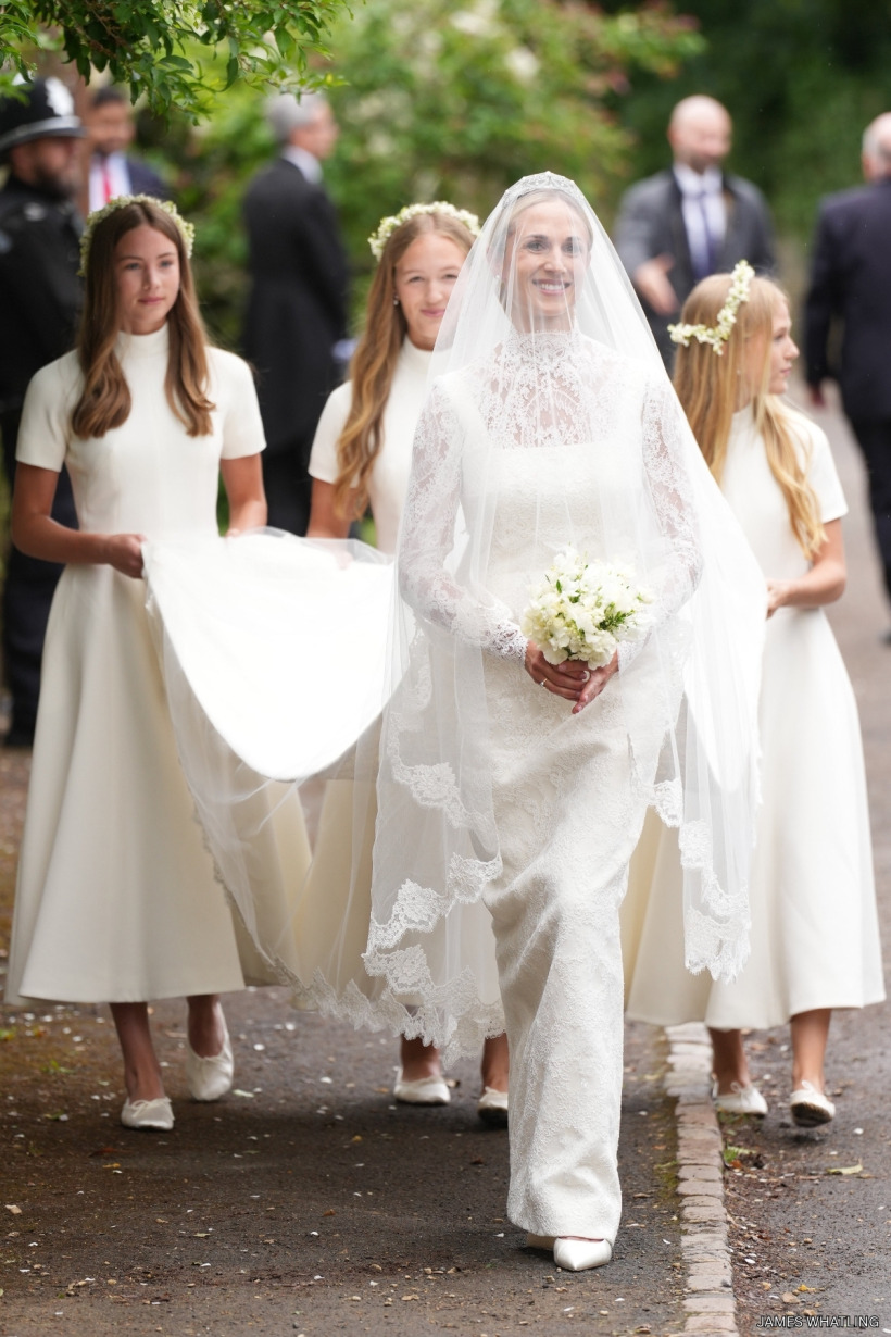 Bride Harriet Sperling in a high-necked ivory lace Emilia Wickstead gown with a long train