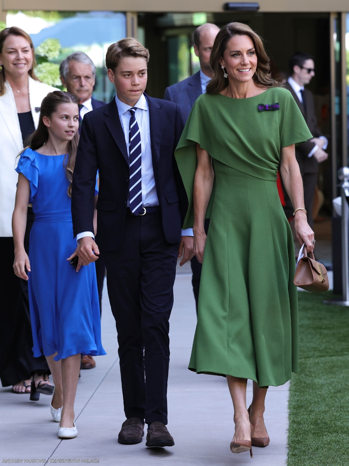 Kate Middleton walking with her children, wearing a green dress at Wimbledon in 2026