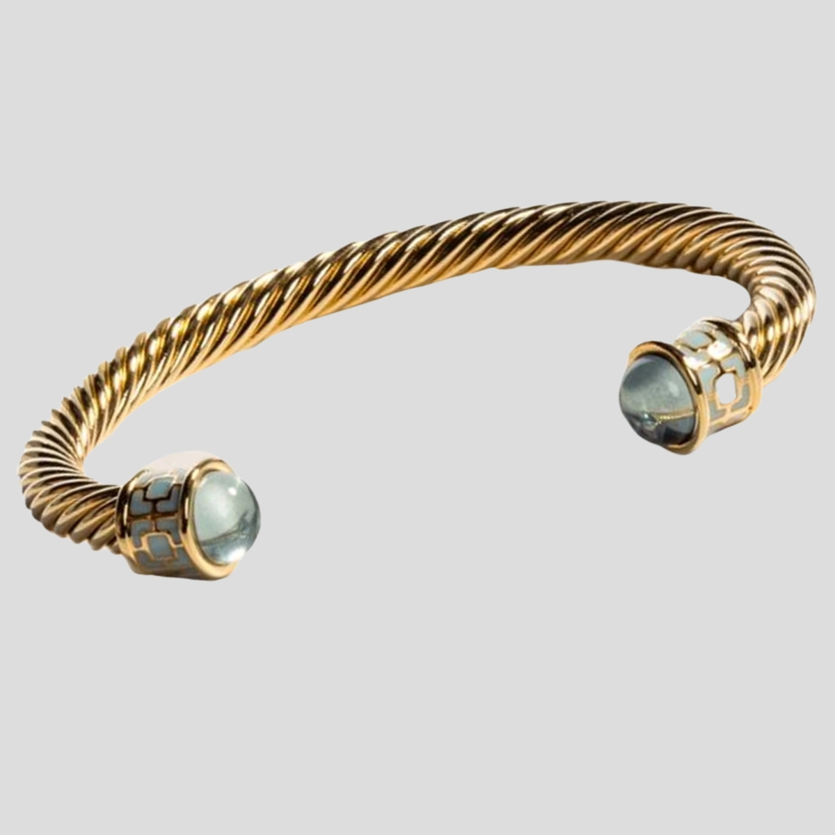 The Halcyon Days Maya Torque bangle with pale blue stones at each end