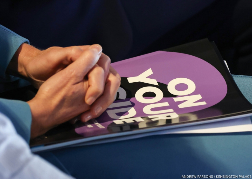 Kate holding the 'On Your Side' suicide prevention toolkit for sport